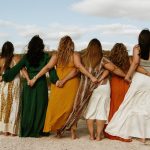 How to plan a retreat in Greece: Women holding hands behind their backs as the bond during a retreat in Greece.