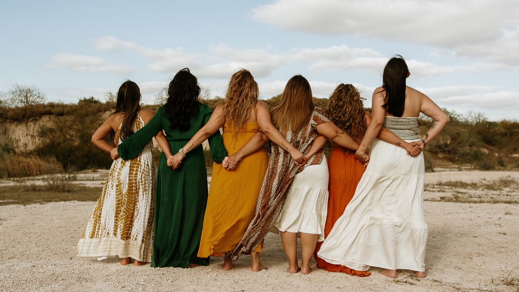 How to plan a retreat in Greece: Women holding hands behind their backs as the bond during a retreat in Greece.